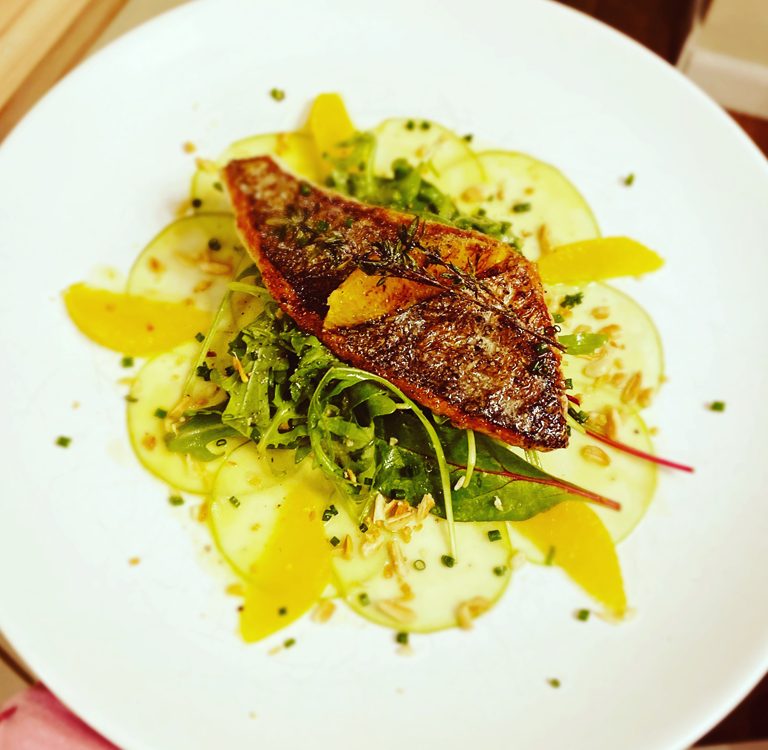 Auf der Haut gebratenes Doradenfilet, Marinierter Apfel und Pflücksalate, Geröstete Pinienkernen, Orangendressing